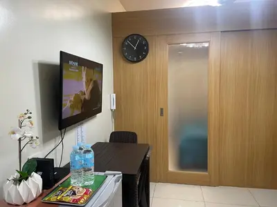 a room with a clock and a table with water bottles at MOA CONDOTEL MANILA in Manila