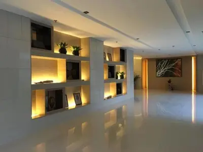 a living room with a white wall with shelves at MOA CONDOTEL MANILA in Manila