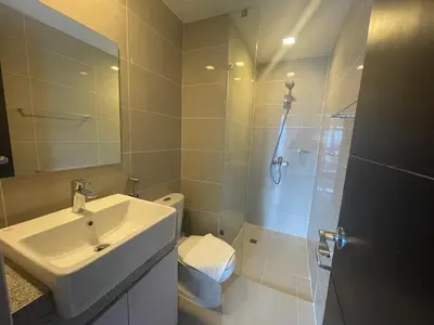a bathroom with a sink and a shower and a toilet at Bright 2-bedroom condo with pool in BGC Uptown in Manila