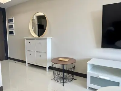 a dressing room with a stool and a mirror at Bright 2-bedroom condo with pool in BGC Uptown in Manila