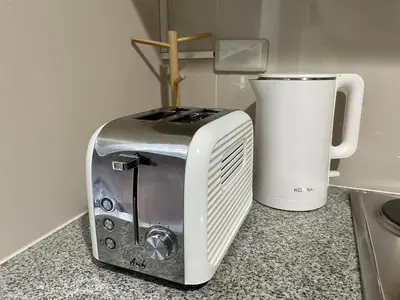 a toaster sitting on a counter next to a coffee maker at Bright 2-bedroom condo with pool in BGC Uptown in Manila