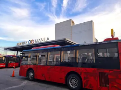 a red bus parked in front of a building at Condo Airport NAIA Terminal-3 One Palm Tree Villas in Manila