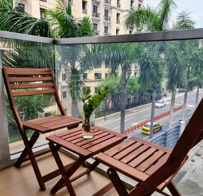 a balcony with two chairs and a table and a window at Condo Airport NAIA Terminal-3 One Palm Tree Villas in Manila