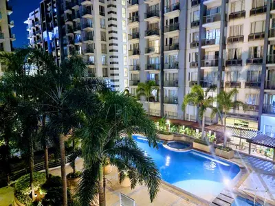 a swimming pool in front of a large building at Condo Airport NAIA Terminal-3 One Palm Tree Villas in Manila