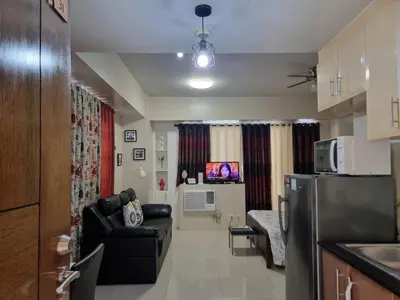 a living room with a couch and a kitchen at Condo Airport NAIA Terminal-3 One Palm Tree Villas in Manila