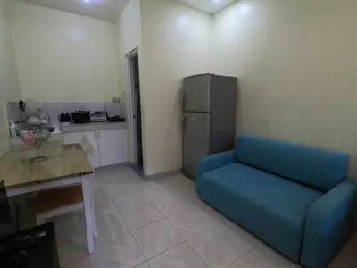 a blue couch in a kitchen with a refrigerator at South Breeze Balibago 3 minutes away from Santa Rosa Commercial Complex in Macabling