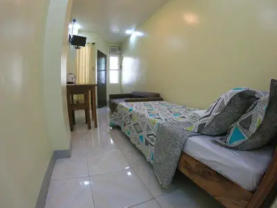 a small bedroom with a bed and a table at South Breeze Balibago 3 minutes away from Santa Rosa Commercial Complex in Macabling
