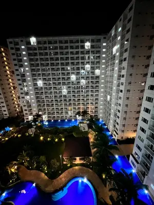 a view of a large building at night with blue lights at Studio Units at Shore Residences Condo MOA Complex near Airport in Manila