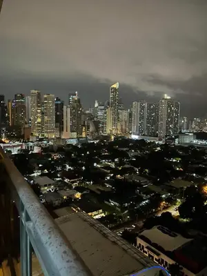 a view of a city at night with tall buildings at Gramercy Residences studio with Balcony Netflix in Manila