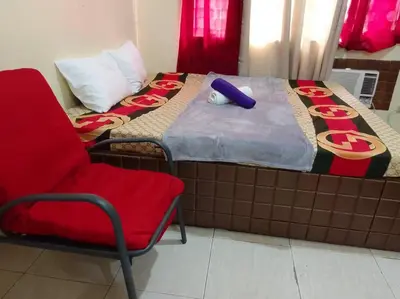 a bedroom with a bed with a red chair next to it at For Rent in Cainta, Rizal: Short / Long Term Lease in Cainta