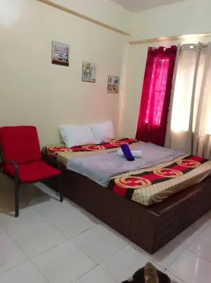 a bedroom with a bed and a red chair at For Rent in Cainta, Rizal: Short / Long Term Lease in Cainta