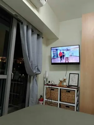 a living room with a flat screen tv on the wall at Posada De Michi - Acqua Private Residences in Manila