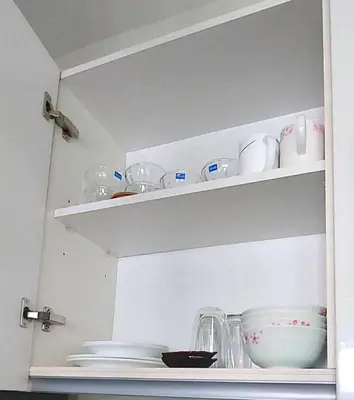 a white shelf with dishes and bowls on it at Posada De Michi - Acqua Private Residences in Manila
