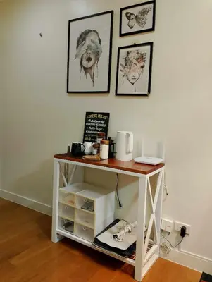 a small white table in a room with pictures on the wall at Posada De Michi - Acqua Private Residences in Manila