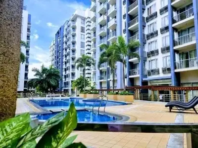 a swimming pool in front of a large apartment building at MRMcondotel in Manila