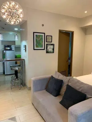 a living room with a couch and a kitchen at MRMcondotel in Manila