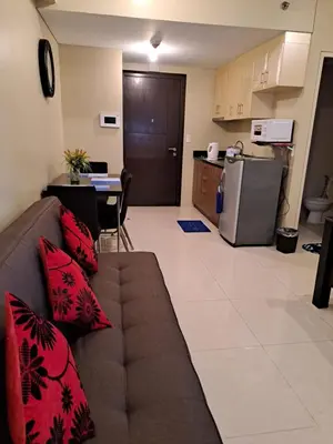 a living room with a couch and a kitchen at MRMcondotel in Manila