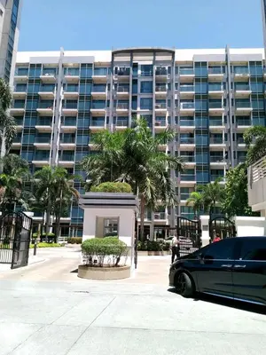 a black car parked in front of a large building at MRMcondotel in Manila