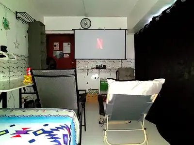 a room with two chairs and a projection screen at Rooftop Condo Makati in Manila
