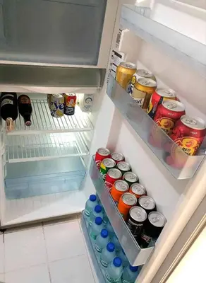 an open refrigerator filled with lots of drinks and soda at Rooftop Condo Makati in Manila