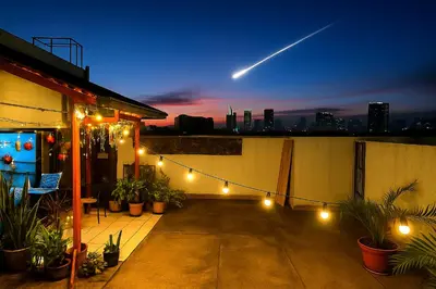 a building with a balcony with lights and plants at Rooftop Condo Makati in Manila
