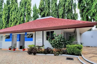 a small white building with a red roof at SCANDIA SUITES AT SOUTH FORBES Homey & Cozy 2-Bedroom Condo in Silang