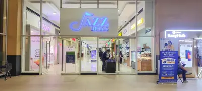 a mall with a man standing in the doorway of a store at 1BR Suite @ SM Jazz Residences - WIFI & Netflix in Manila