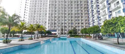 a large swimming pool in front of a large building at 1BR Suite @ SM Jazz Residences - WIFI & Netflix in Manila