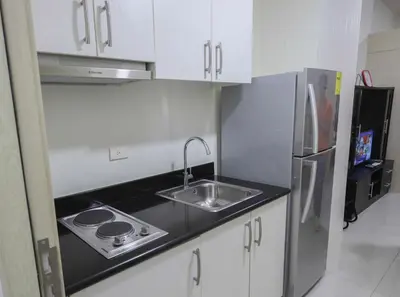 a small kitchen with a sink and a refrigerator at 1BR Suite @ SM Jazz Residences - WIFI & Netflix in Manila