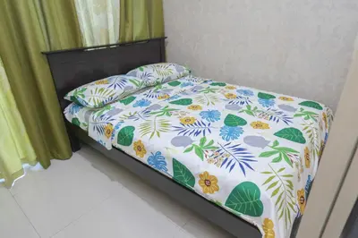 a bedroom with a bed with a floral bedspread at 1BR Suite @ SM Jazz Residences - WIFI & Netflix in Manila