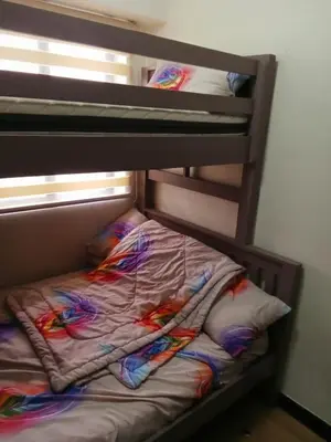 a bunk bed with colorful blankets and pillows on it at Joey's Place Calathea DMCI in Manila