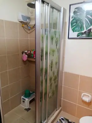 a shower with a glass door with plants on it at Joey's Place Calathea DMCI in Manila
