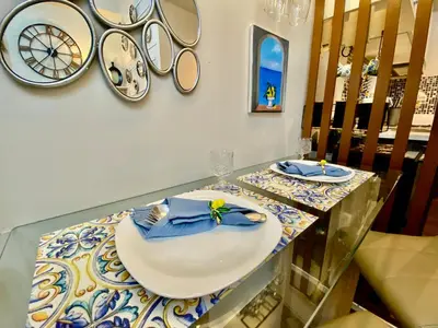 a dining room table with a plate and mirrors on the wall at SMDC Air Residence-LucasCove Sorrento Vibes in Makati in Manila