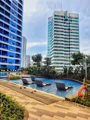 a swimming pool with lounge chairs in a city at SMDC Air Residence-LucasCove Sorrento Vibes in Makati in Manila