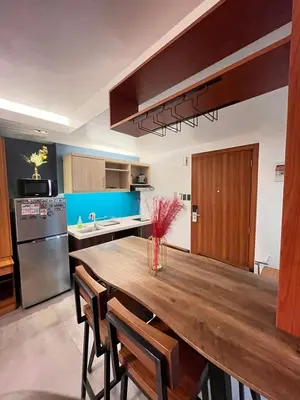 a kitchen with a large wooden table and chairs at 1 bedroom Service Aprtmnt 2pax allows other 4pax 25011 in Cubao Quezon City in Manila