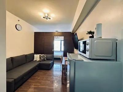 a living room with a couch and a tv at Heart of Makati, Fully furnished condo, cbd central location in Manila