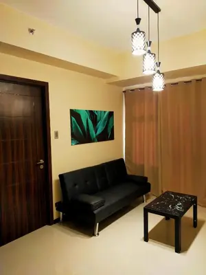 a living room with a black couch and a table at The Radiance Manila Bay in Manila