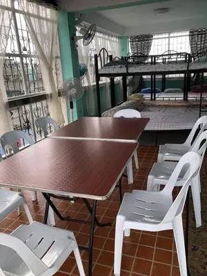 a table and chairs in a room with a table andadders at THE MANSION- Near NAIA Airport Terminal PASAY in Manila