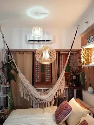 a hanging hammock in a room with a couch at Balay Sa Air, Beyond Ordinary at Air Residences Makati in Manila