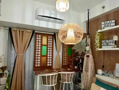 a kitchen with a bar with stools in it at Balay Sa Air, Beyond Ordinary at Air Residences Makati in Manila