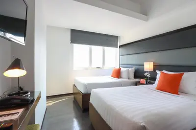 a hotel room with two beds and a television at Privato Ortigas in Manila