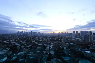 an aerial view of a city with the sun setting at Privato Ortigas in Manila