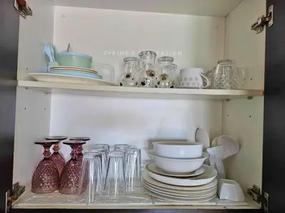 a shelf filled with glasses and bowls and plates at The Rochester - Flat in Pasig near BGC in Manila