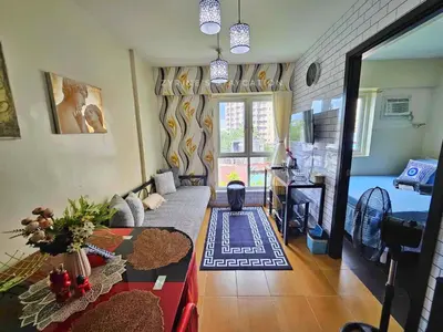 a living room with a couch and a table at The Rochester - Flat in Pasig near BGC in Manila