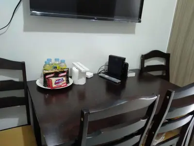 a wooden table with a phone and drinks on it at Cozy 619 shore2 residence tower2 near MOA in Manila