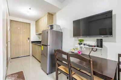 a kitchen with a stainless steel refrigerator and a table at Cozy 619 shore2 residence tower2 near MOA in Manila