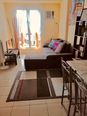 a living room with a couch and a window at The Rochester Parklane Condominium in Manila