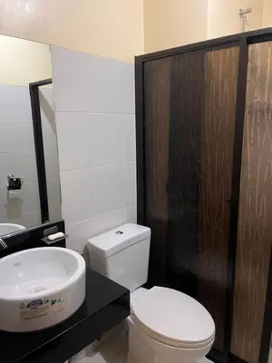 a bathroom with a white toilet and a sink at The Rochester Parklane Condominium in Manila
