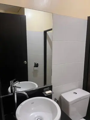 a bathroom with a white toilet and a sink at The Rochester Parklane Condominium in Manila
