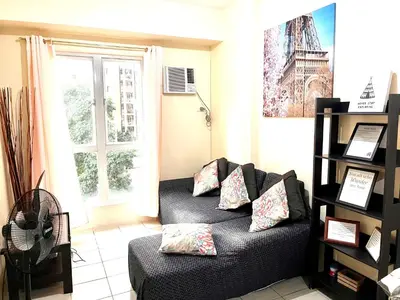a living room with a couch and a window at The Rochester Parklane Condominium in Manila